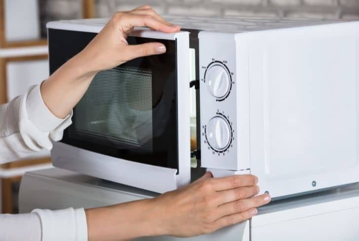women-closing-microwave-door